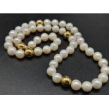 An 18K Yellow Gold Necklace with 48 round Cultured Pearls. 22.59g total weight. Comes with a W.G.