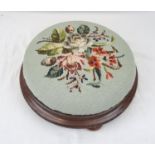 An Antique Ladies Tuffet, or Footstool. Floral cloth pattern on a wood base. In good condition