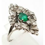An Antique Victorian 18K White Gold Emerald and Diamond Ring. A central Colombian oval cut emerald