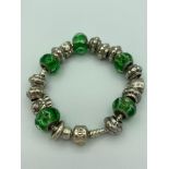 PANDORA SILVER BRACELET Full of charms to include Silver and green marble glass. 19cm.
