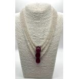 A Three-Strand Moonstone and Ruby Bead Necklace. Moonstone - 5mm. Ruby - 21mm. Colour enhanced