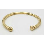 A 9 K yellow gold solid torque bangle. Weight: 33.5 g.