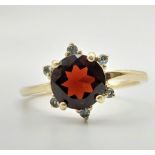 An Antique 9k Yellow Gold Red and Green Garnet Ring. Central blood red garnet with a halo of six