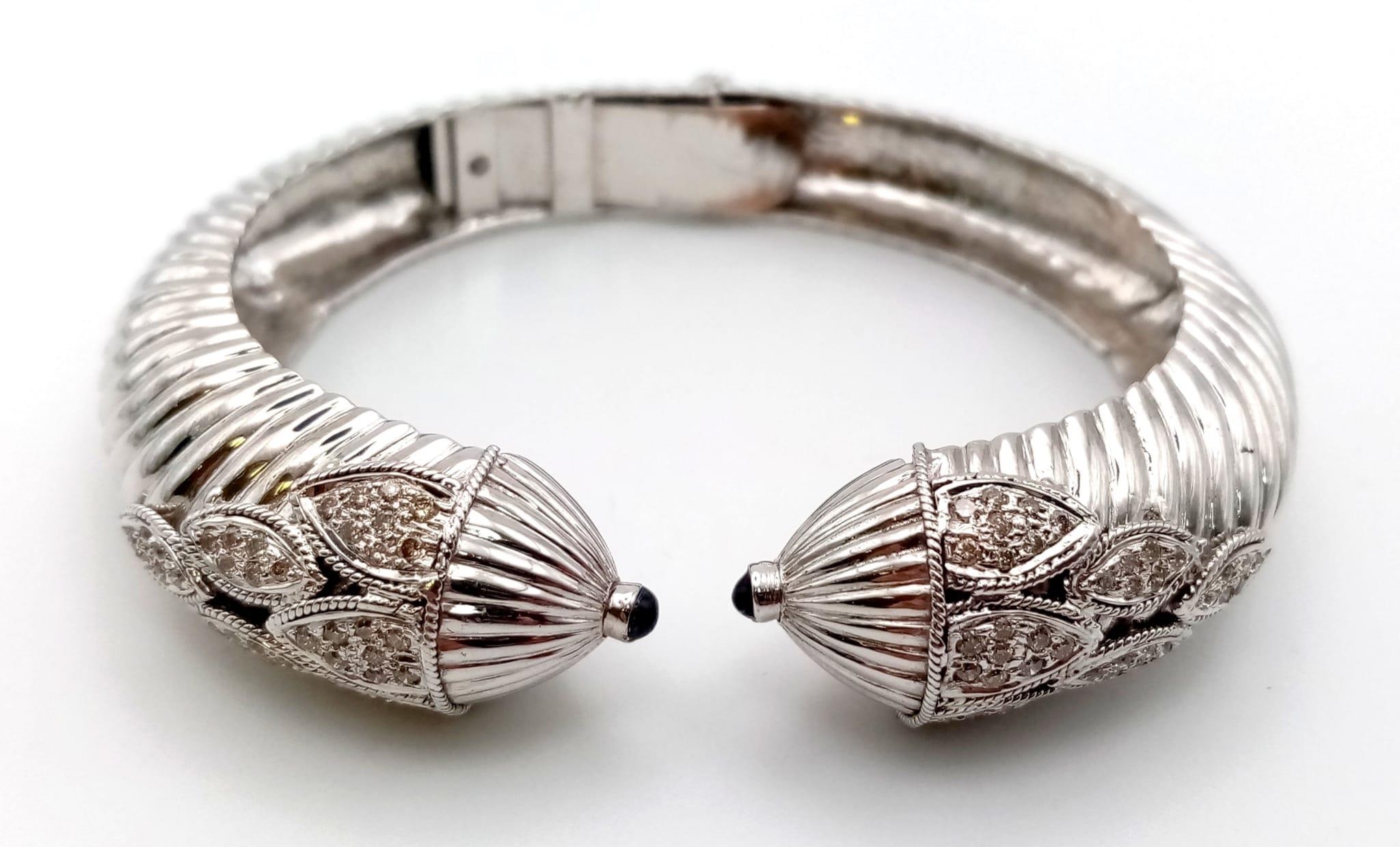 A 14K WHITE GOLD HINGED DIAMOND BANGLE WITH SAPPHIRE TIPS , BEAUTIFULLY SHAPED AND DESIGNED. 39.6gms