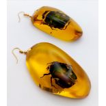 An amber resin pendant and earrings set with beautiful beetle inclusions. Large proportions for