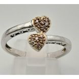 A 9K Gold (rhodium plated) Pink Sapphire Heart Ring. Crossover hearts each with six pink