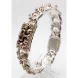A gents, sterling silver (stamped S925) chain bracelet with human skulls decoration (probably of