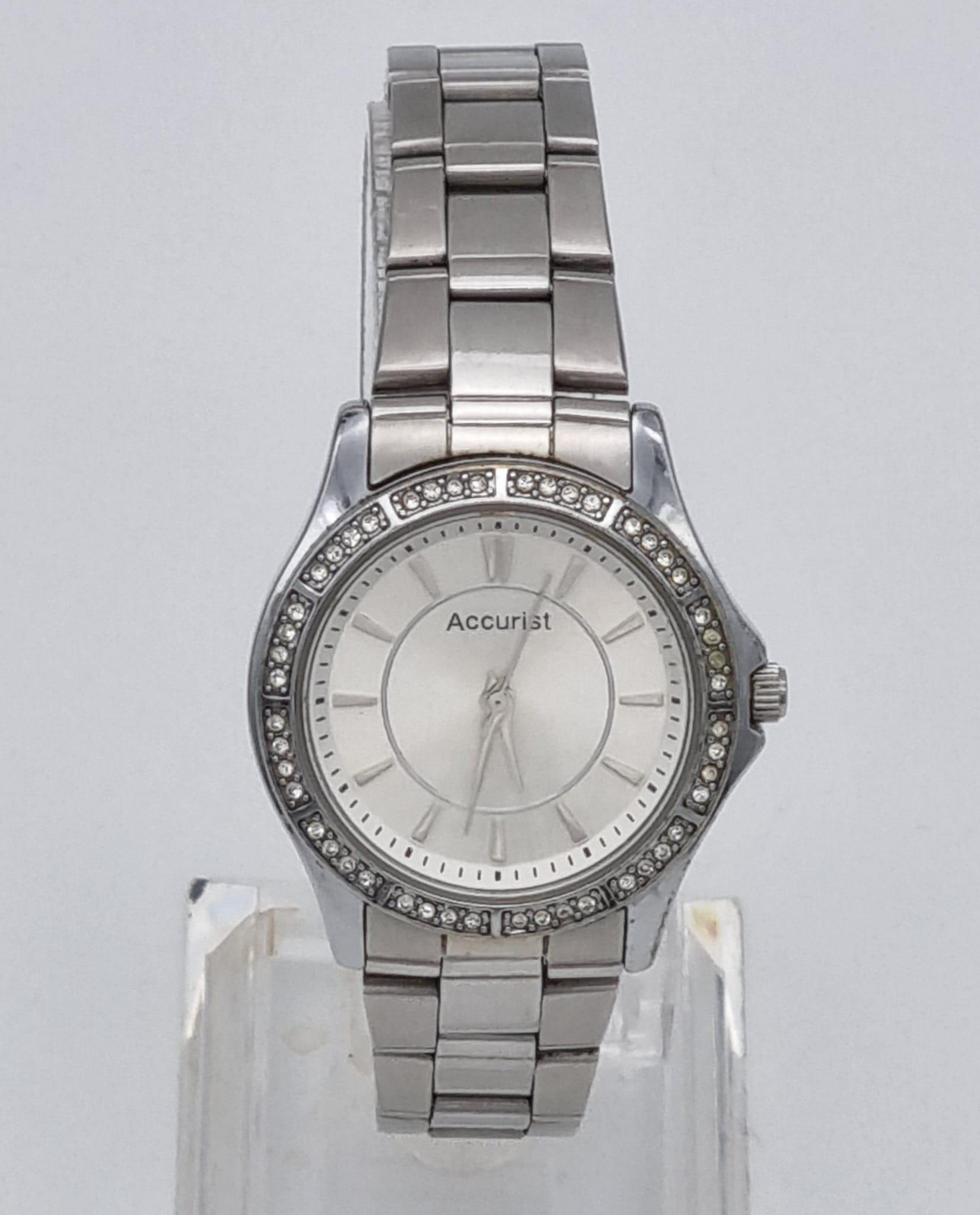 A Quality Accurist Ladies Diamonte Watch. Stainless steel strap and case - 28mm. Silver tone dial.