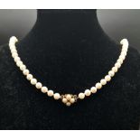 A SINGLE ROW OF CULTURED PEARLS WITH 9K GOLD CLASP 68cms IN LENGTH