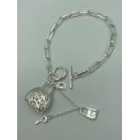 Bracelet with T-bar fastening and filigree handbag pendant with safety chain and padlock marked
