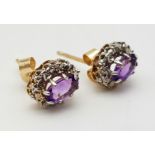 A PAIR OF AMETHYST AND DIAMOND CLUSTER EARRING STUDS SET IN 9K GOLD.