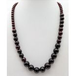 A Graduated Garnet Bead Necklace. 10mm largest bead. 42cm. Colour enhanced