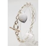 A sterling silver bracelet with heart tag. Weight: 18.4 g.