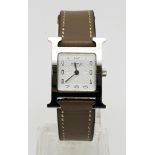 A LADIES HERMES "H" WATCH IN PLATINUM WITH QUARTZ MOVEMENT AND BROWN LEATHER STRAP 22cms
