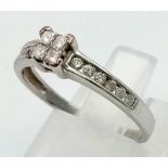 A 9K White Gold Princess-Cut Diamond Ring. Four clean princess-cut central diamonds supported by two