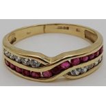A 9 K yellow gold ring with rubies and diamonds in a cross over design. Size: n, weight: 1.9 g.