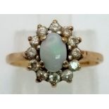 A 9 K yellow gold ring with an opal cabochon surrounded by white sapphires. Ring size: I, weight: