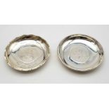 A pair of small silver plates (diameter 9 cm) incorporating a Honk Kong silver dollar (Date 1897,