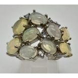 An Opal and Silver Ring. Nine opal gemstones set in silver. Size P. 5.91g