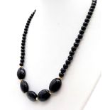 A Black Oval and Small Bead Agate Necklace. 42cm