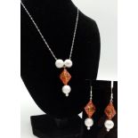 A glamorous sterling silver pendant (with chain) and earrings set with amber resin. Necklace length: