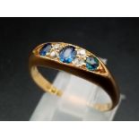 An 18ct yellow gold slim band with three sapphires alternate between double set diamonds, ring