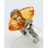 A very attractive 18 K white gold ring with a beautiful large citrine and diamonds. Size: O, weight: