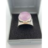 SILVER MOONSTONE RING having large pale lilac moonstone cabochon set into wide Silver Band. Size U -