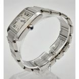 THE FAMOUS CARTIER TANK WATCH ON A STAINLESS STEEL STRAP WITH ROMAN NUMERALS AND SAPPHIRE CROWN.