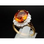 A 5ct citrine ring with a halo of diamonds set in 18ct white and yellow gold. 5.27 carat Citrine 0.