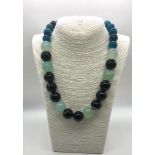 A Multi-Coloured Graduated Onyx Bead Necklace. Blue, pale green and black beads 14-20mm. 48cm