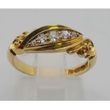 An 18K Yellow Gold Vintage Diamond Ring. Five clean, bright round-cut diamonds graduate from both