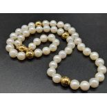 An 18K Yellow Gold Necklace with 48 round Cultured Pearls and 18k gold spacers. 22.59g total weight.