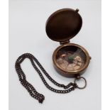 A brass compass with immobiliser, brass chain and inscription BERLIN 1936 in a wooden box with