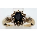 A 9 K yellow gold ring with an oval cut sapphire surrounded by a halo of diamonds. Ring size: J