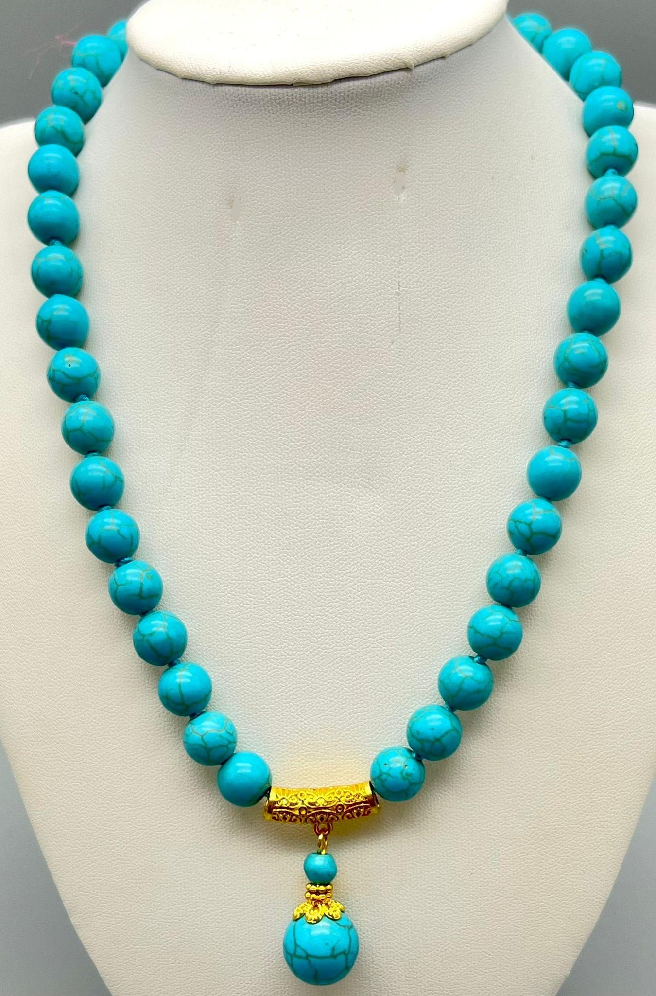 A Turquoise Bead and Pendant Necklace. Gilded decoration. 42 and 3cm. Largest bead 14mm