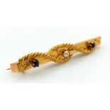 An Antique 15K Yellow Gold Sapphire and Seed Pearl Bar Brooch. Two sapphires and a seed pearl in a