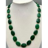 A Green Malachite Flat Oval Bead Necklace. Gilded spacers and clasp. 17mm. 42cm