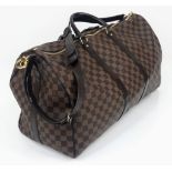 A Louis Vuitton Checked Canvas Keepall Bag. Monogram Canvas and leather exterior. Comes with a shoul