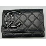 A Chanel Soft Black Leather Wallet. Checked diamond design with Chanel logo. Red interior with zip a