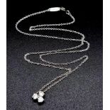 A Tiffany and Co Aria Diamond Pendant on a 950 Platinum Necklace. Three brilliant round cut diamonds