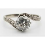 A Beautiful 18K White Gold and Platinum Diamond Crossover Ring. A clean brilliant round cut 1ct cent