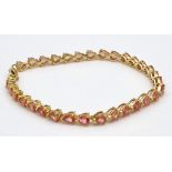 An 18K Yellow Gold Pink Topaz Tennis Bracelet. 31 beautiful clean topaz teardrops create a stunning