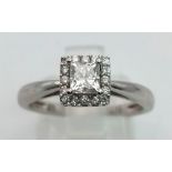 An 18K White Gold Diamond Princess Cut Ring. Central diamond surrounded by a square of 16 smaller di