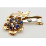 AN 18K YELLOW AND WHITE GOLD DIAMOND AND SAPPHIRE BROOCH IN FLORAL DESIGN. 19gms 0.60ct