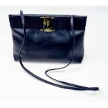 A Feregamo Black Leather Clutch Bag. Gilded belt buckle exterior. Velcro pocket interior. In good