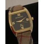 Ladies quartz wristwatch,having square face with black dial and showing BURBERRY Swiss made. Back of