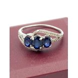 SILVER and TOPAZ RING having three sapphire blue Topaz set to top in an Infiniti mount with silver
