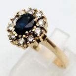 A 14 k yellow gold ring with an oval cut sapphire surrounded by a halo of diamonds (0.5 carats).