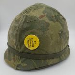 A Vietnam War Era US M1 Helmet and Liner. With reversible camouflage cover.